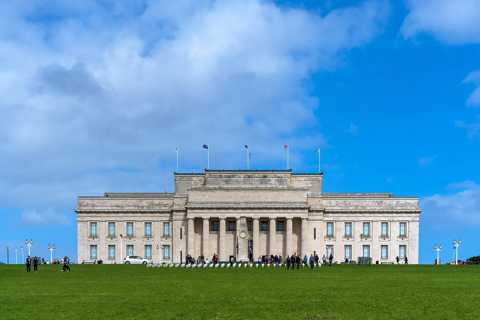 The front of Auckland War Memorial Museum, a columned neoclassical building in pale stone, seen across the lawn in front of it